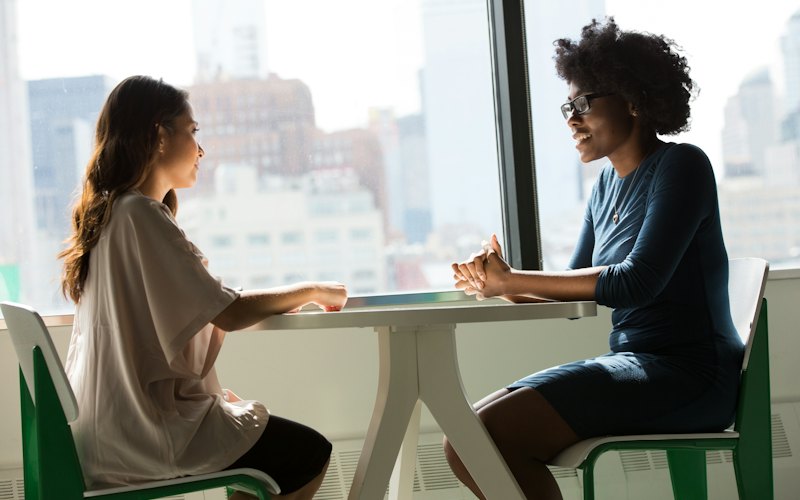 Two adults in conversation at a table
