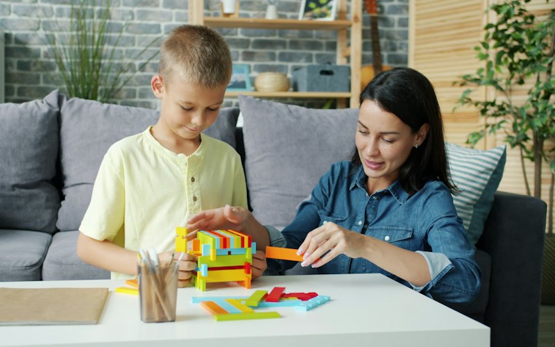 A mother and son building with colourful blocks together